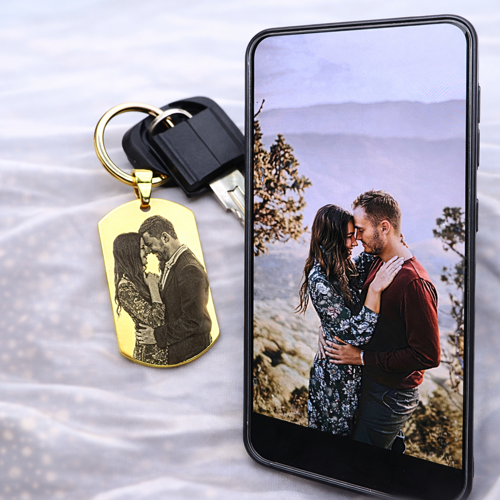 Individueller Foto Schlüsselanhänger in Gold neben Smartphone – personalisiertes Geschenk